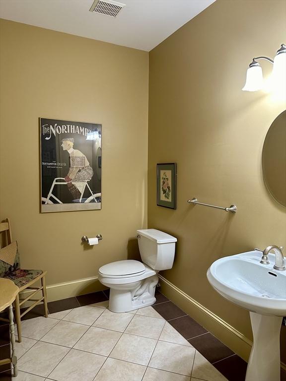 bathroom featuring tile patterned flooring, visible vents, toilet, and baseboards