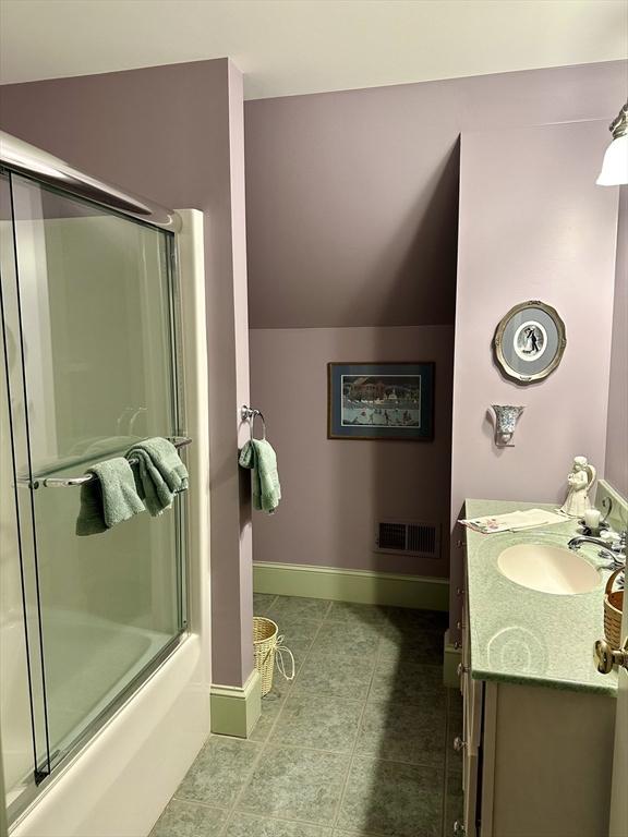 full bathroom with vanity, baseboards, visible vents, lofted ceiling, and tile patterned floors