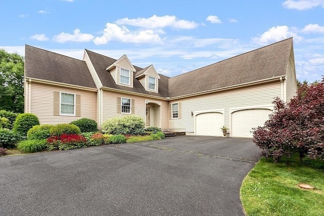 cape cod house with aphalt driveway, a garage, and roof with shingles