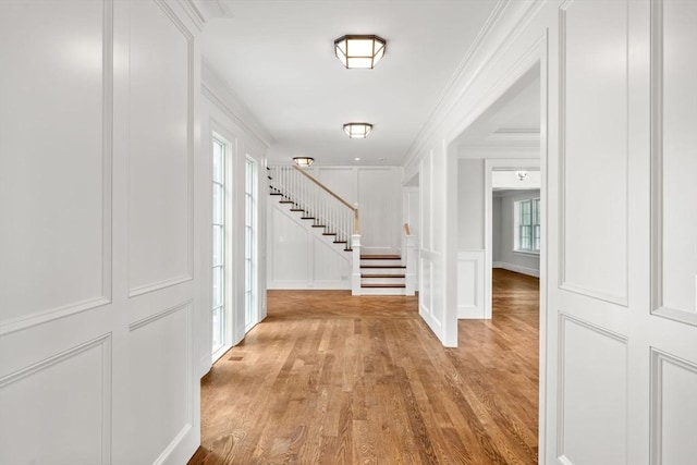61 Heath St, Brookline, MA 02445 - foyer featuring a decorative wall, stairway, wood finished floors, and ornamental molding