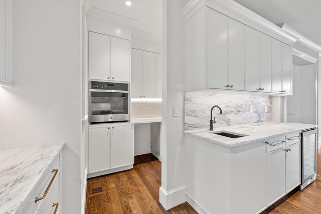 61 Heath St, Brookline, MA 02445 - kitchen featuring stainless steel oven, a sink, beverage cooler, and wood finished floors