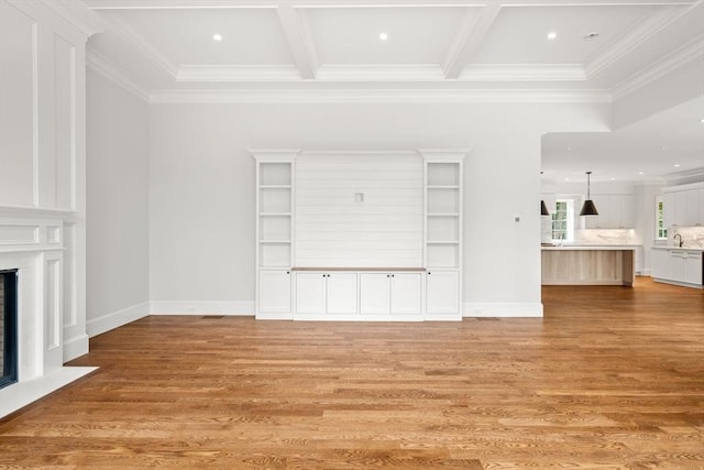 61 Heath St, Brookline, MA 02445 - unfurnished living room featuring ornamental molding, light wood finished floors, a fireplace with flush hearth, coffered ceiling, and beamed ceiling
