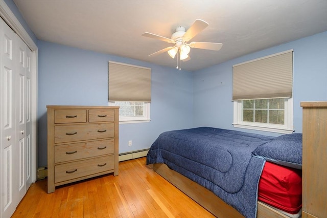 bedroom with ceiling fan, a closet, light hardwood / wood-style floors, and a baseboard radiator