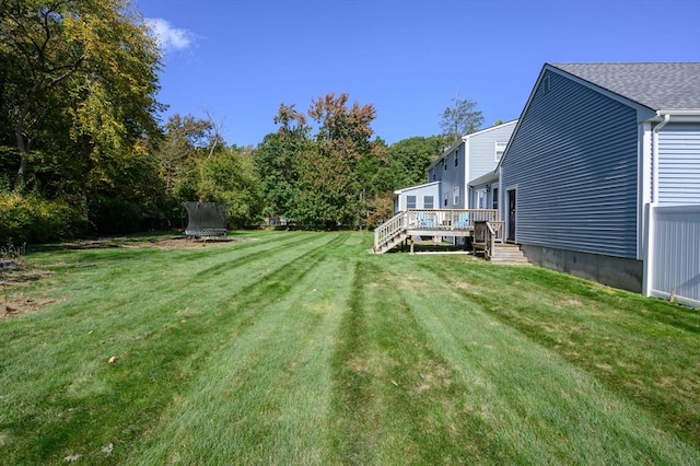 view of yard featuring a deck and a trampoline