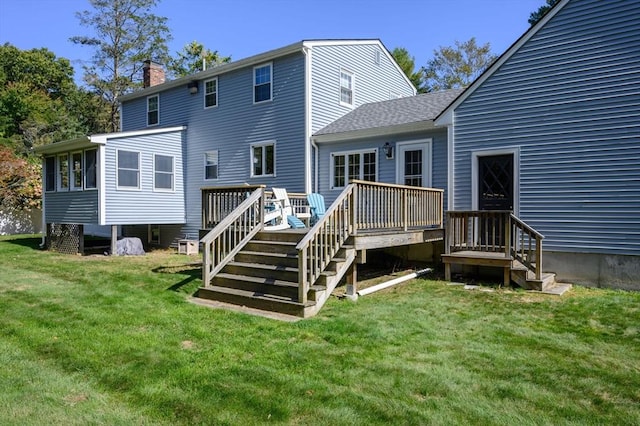 back of property with a yard and a wooden deck