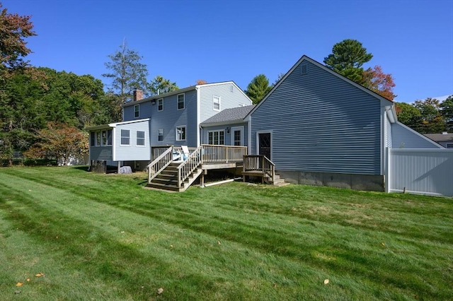 back of house featuring a lawn and a wooden deck