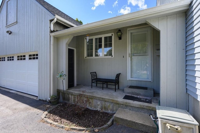 entrance to property featuring a porch and a garage