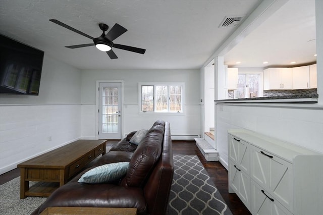 living room featuring dark hardwood / wood-style floors, ceiling fan, and a baseboard radiator