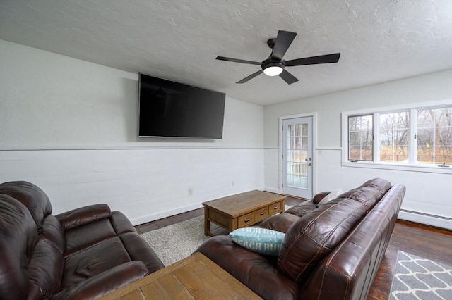 living room featuring dark hardwood / wood-style floors, ceiling fan, a textured ceiling, and a baseboard heating unit