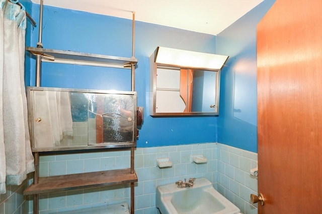 bathroom with sink and tile walls