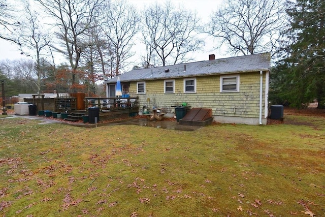 back of property with a yard, central AC unit, and a wooden deck