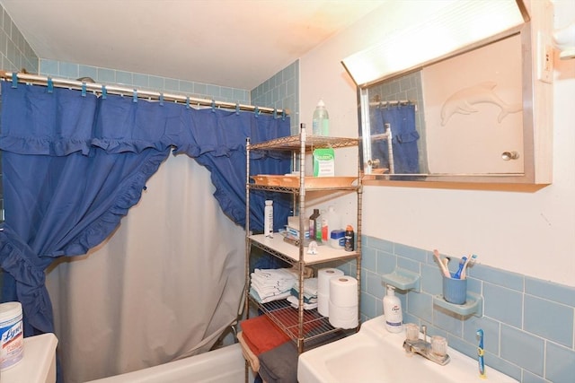 full bathroom featuring sink, shower / bath combination with curtain, tile walls, and toilet