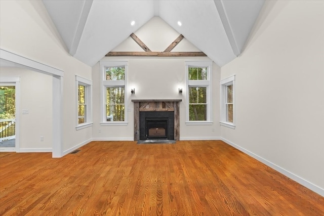 unfurnished living room featuring wood-type flooring and high vaulted ceiling