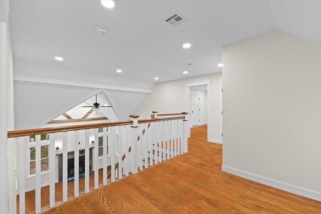 corridor featuring vaulted ceiling and light hardwood / wood-style floors