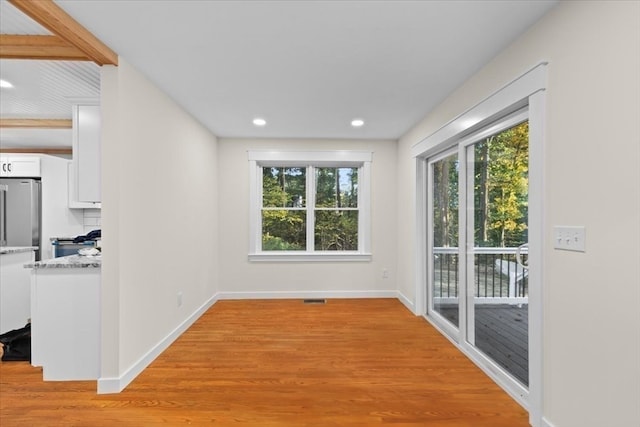 unfurnished dining area featuring light wood-type flooring