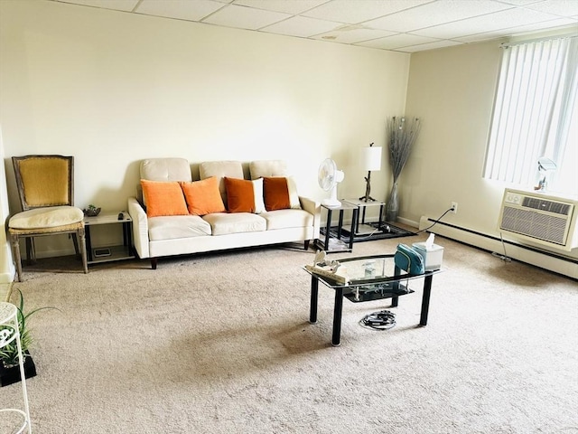 carpeted living room featuring an AC wall unit, a drop ceiling, and a baseboard radiator