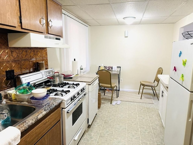 kitchen featuring white appliances and a paneled ceiling