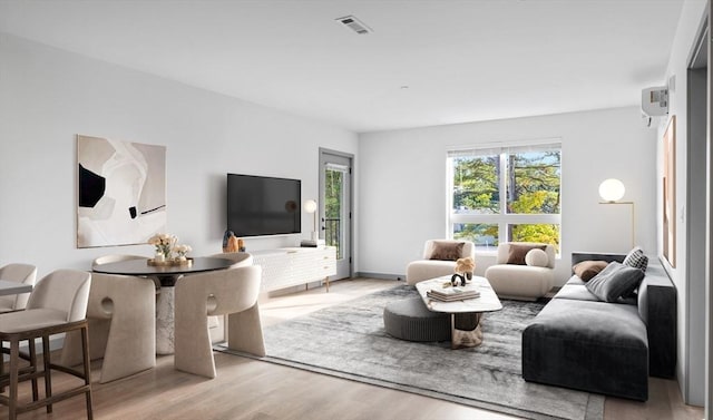 living area featuring light wood-type flooring and visible vents