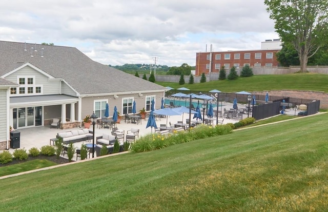 view of swimming pool featuring a patio area, a yard, and fence