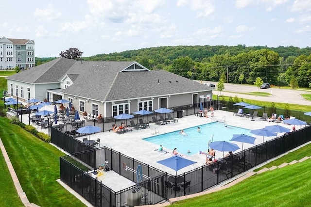 community pool with a yard, fence, and a patio area