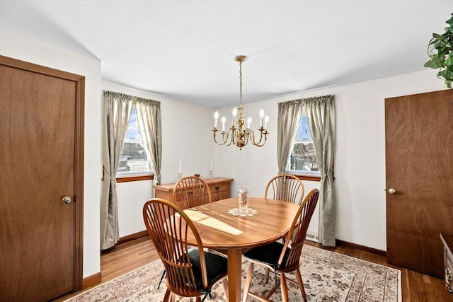 dining space featuring hardwood / wood-style flooring and an inviting chandelier