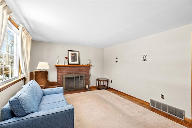 living room featuring hardwood / wood-style floors and a brick fireplace