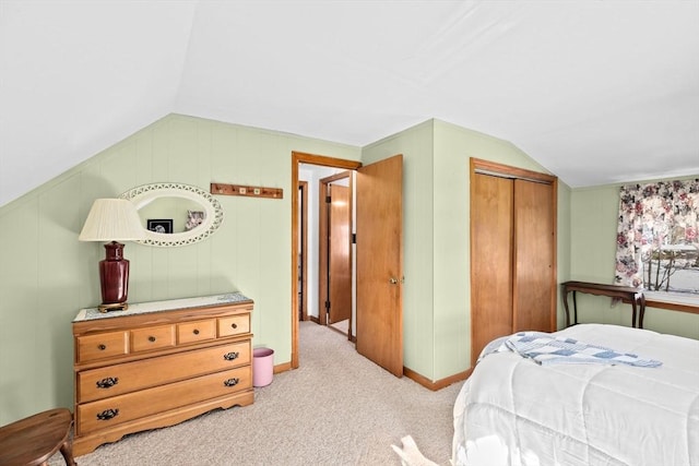 bedroom with light carpet, vaulted ceiling, and a closet