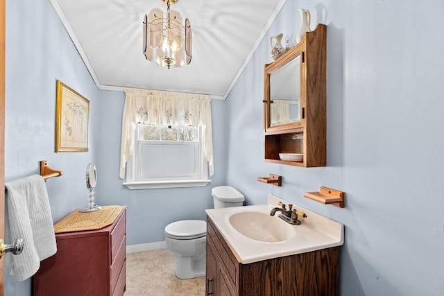 bathroom with ornamental molding, toilet, a chandelier, and vanity