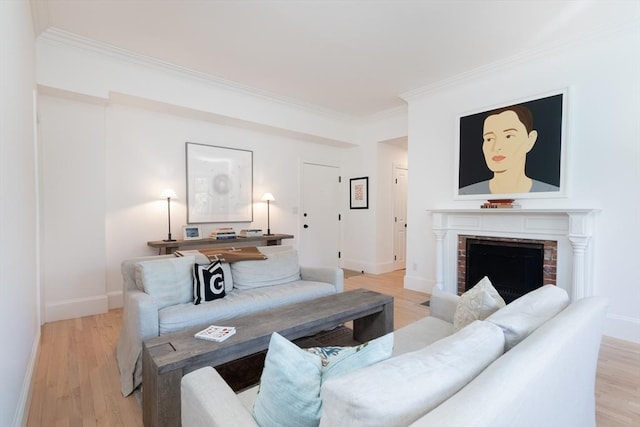 living room with crown molding, a fireplace, and light wood-type flooring