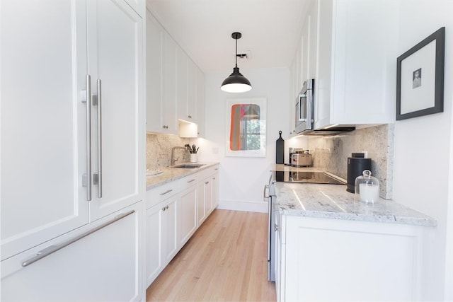 bar featuring decorative light fixtures and white cabinetry