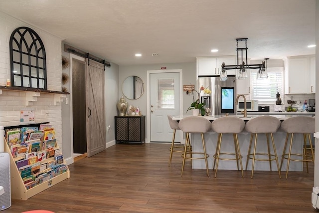 22 Hillsdale Rd, Holbrook, MA 02343 - kitchen with stainless steel fridge with ice dispenser, a barn door, a breakfast bar, white cabinetry, and an island with sink
