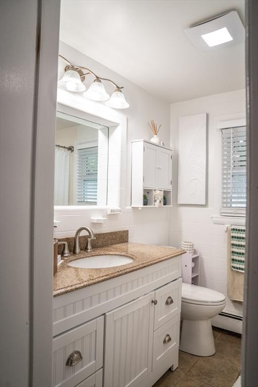 22 Hillsdale Rd, Holbrook, MA 02343 - bathroom featuring a baseboard radiator, vanity, tile patterned floors, and tile walls