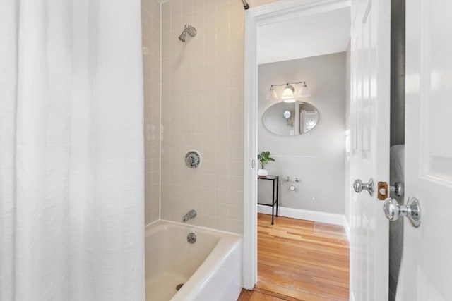 bathroom featuring shower / tub combo, wood finished floors, and baseboards