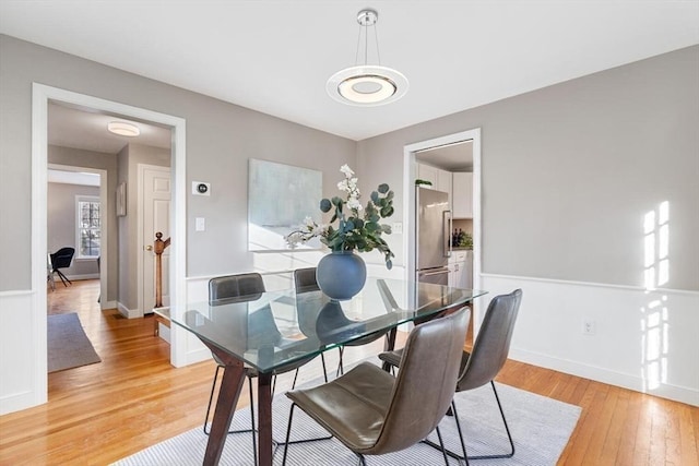 dining area featuring baseboards and light wood-style floors