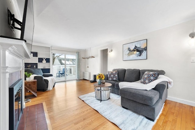 living area with a fireplace, wood finished floors, and baseboards