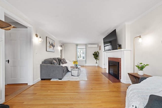 living area with crown molding, light wood-type flooring, baseboards, and a brick fireplace