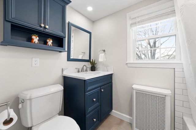 bathroom with toilet, recessed lighting, vanity, baseboards, and radiator heating unit