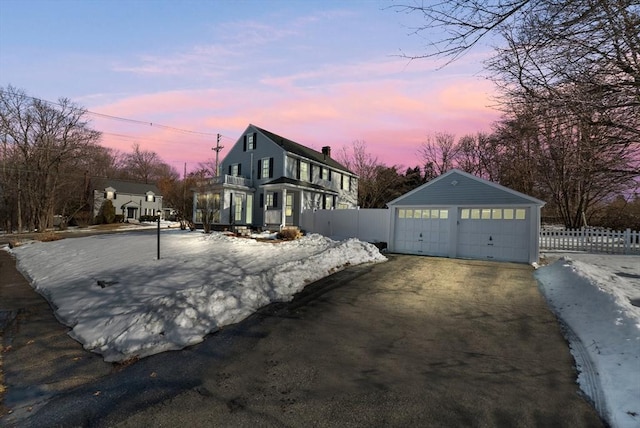 view of property exterior featuring an outbuilding, fence, and a detached garage