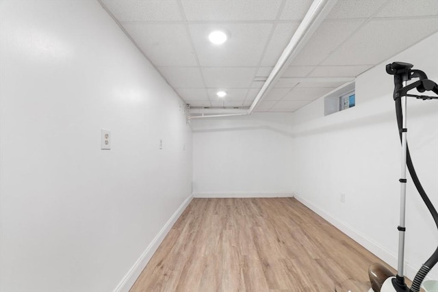 finished basement with light wood-type flooring, baseboards, a drop ceiling, and recessed lighting