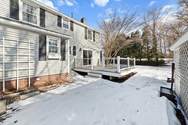 snow covered house featuring crawl space, a chimney, and a wooden deck