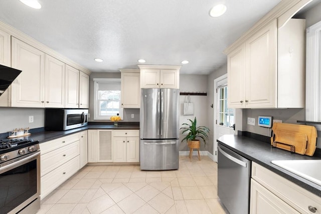 kitchen with dark countertops, plenty of natural light, appliances with stainless steel finishes, and recessed lighting