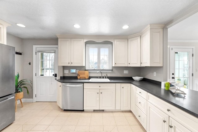 kitchen featuring light tile patterned floors, dark countertops, stainless steel appliances, a sink, and recessed lighting