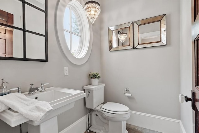59 Elm St, Concord, MA 01742 - bathroom featuring a chandelier, baseboards, toilet, and a sink
