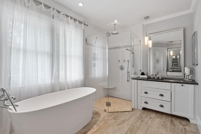 59 Elm St, Concord, MA 01742 - full bathroom with vanity, ornamental molding, a stall shower, a soaking tub, and wood finished floors