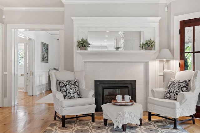 59 Elm St, Concord, MA 01742 - sitting room featuring light wood-style flooring, crown molding, and a brick fireplace