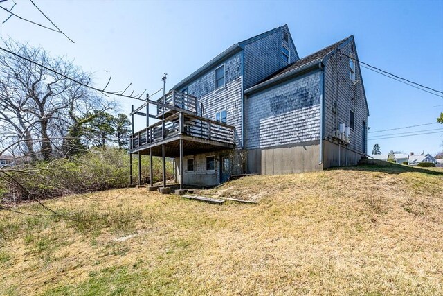rear view of property with a wooden deck and a lawn