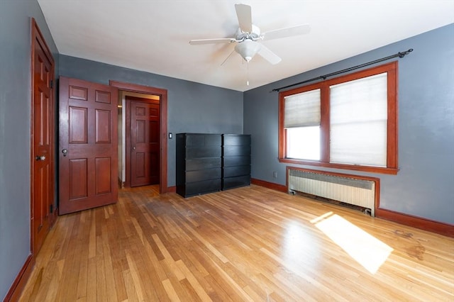 unfurnished bedroom featuring radiator heating unit, ceiling fan, and light hardwood / wood-style floors