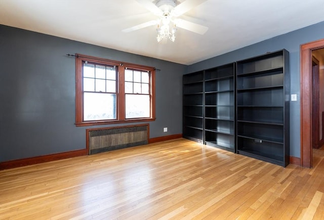 spare room featuring ceiling fan, radiator, and light hardwood / wood-style floors