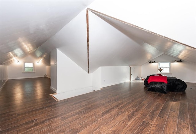 bonus room with dark hardwood / wood-style floors and vaulted ceiling