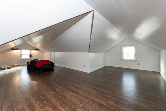 bonus room with lofted ceiling and dark wood-type flooring